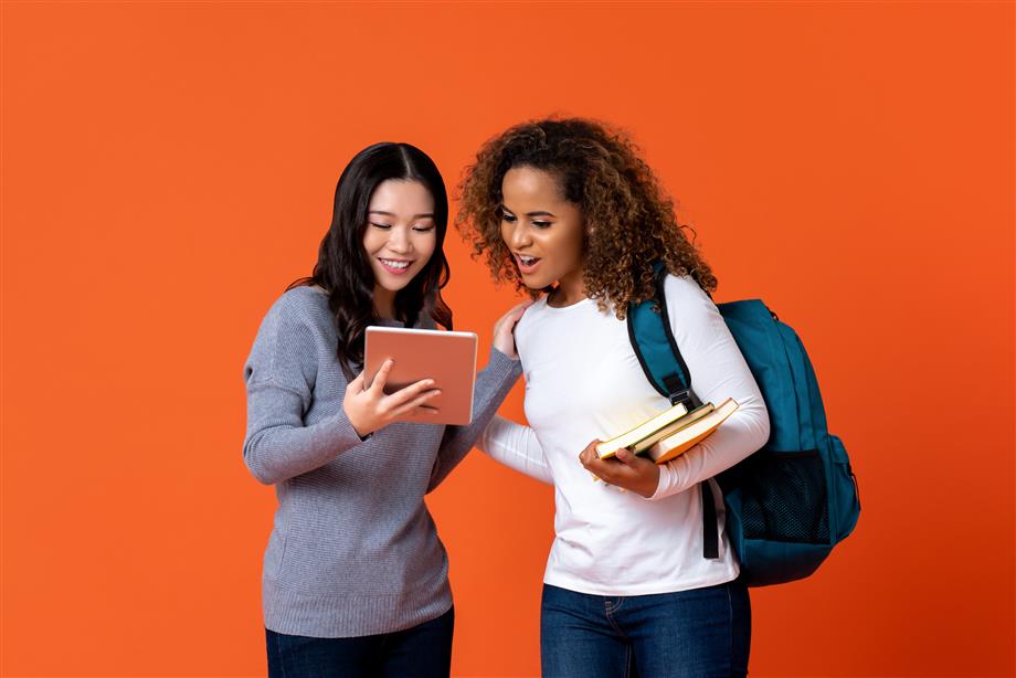 Two female students accessing resources on a tablet.